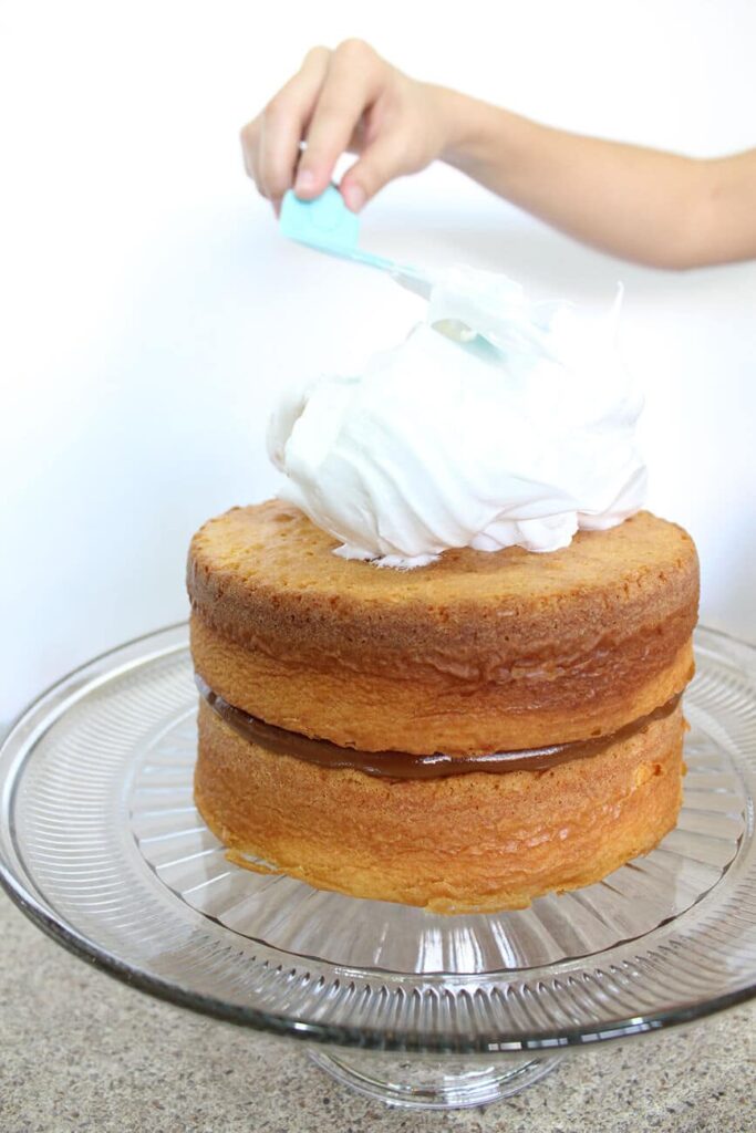 Pastel de vainilla con relleno de dulce de leche y cubierto con merengue