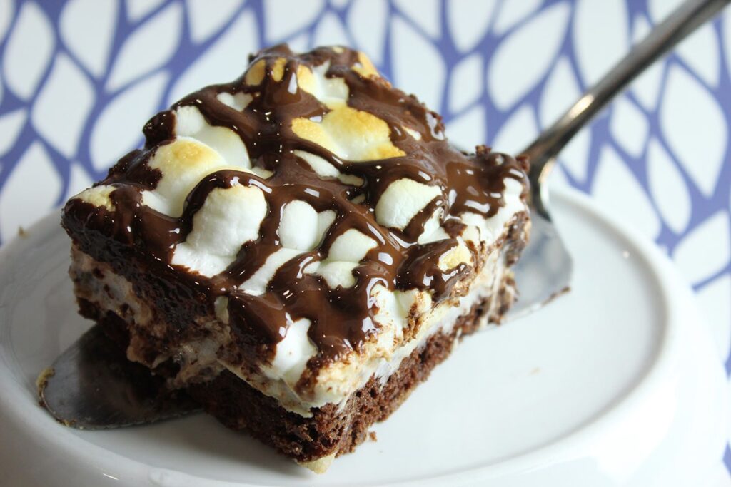 Side perspective displaying the graham cracker crust and fudge layers of the s'mores brownies.