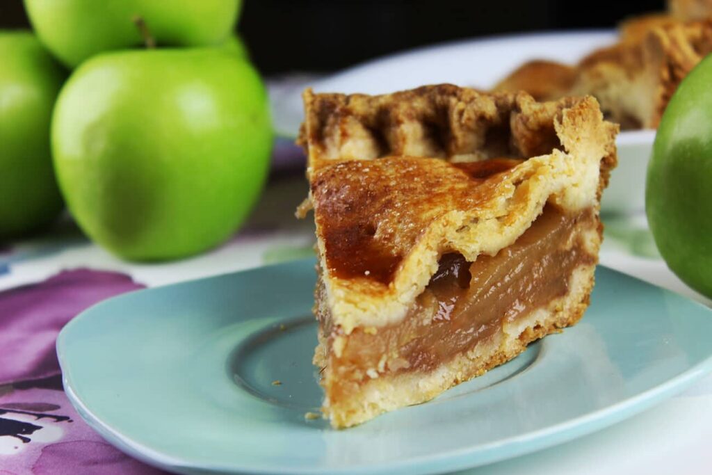Side perspective showing the fruit filling packed inside the baked apple pie crust.
