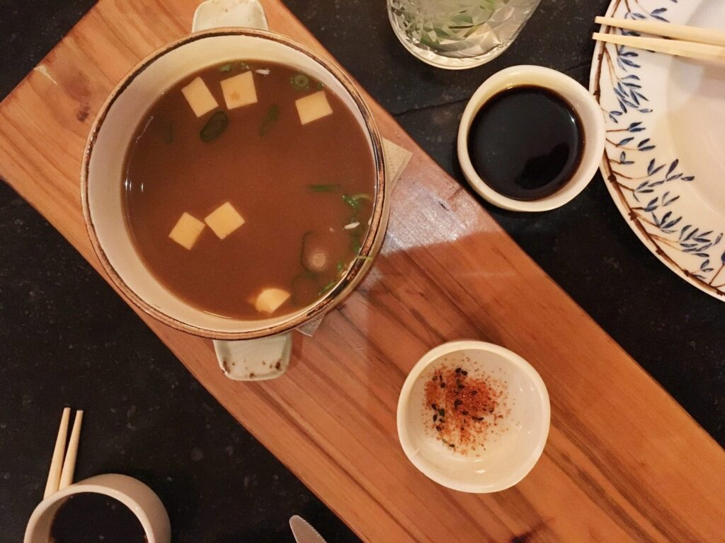 Tazón caliente de tradicional sopa miso adornada con cebollín y tofu.