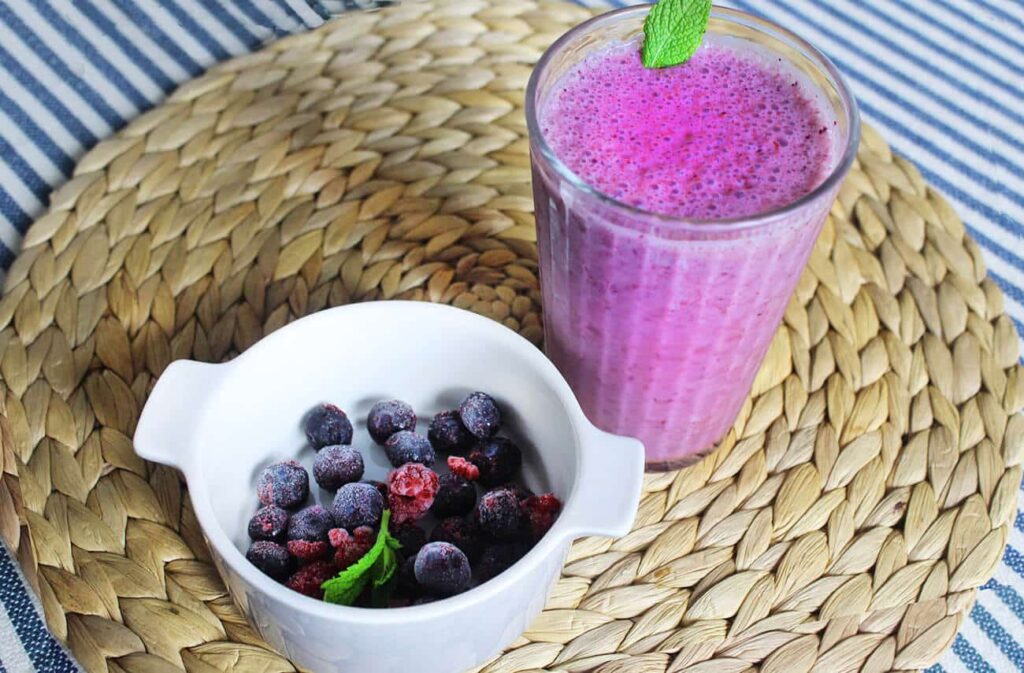 Side perspective displaying a filled glass of the mixed berries banana smoothie.