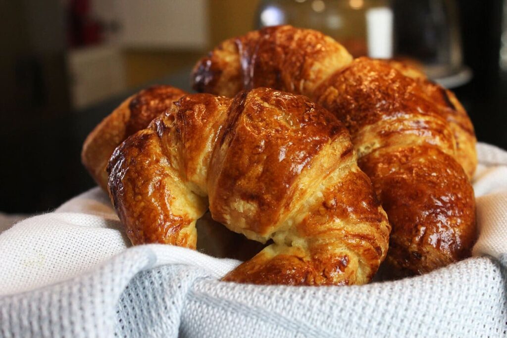 Presentation of a completed fresh batch of homemade flaky croissants.