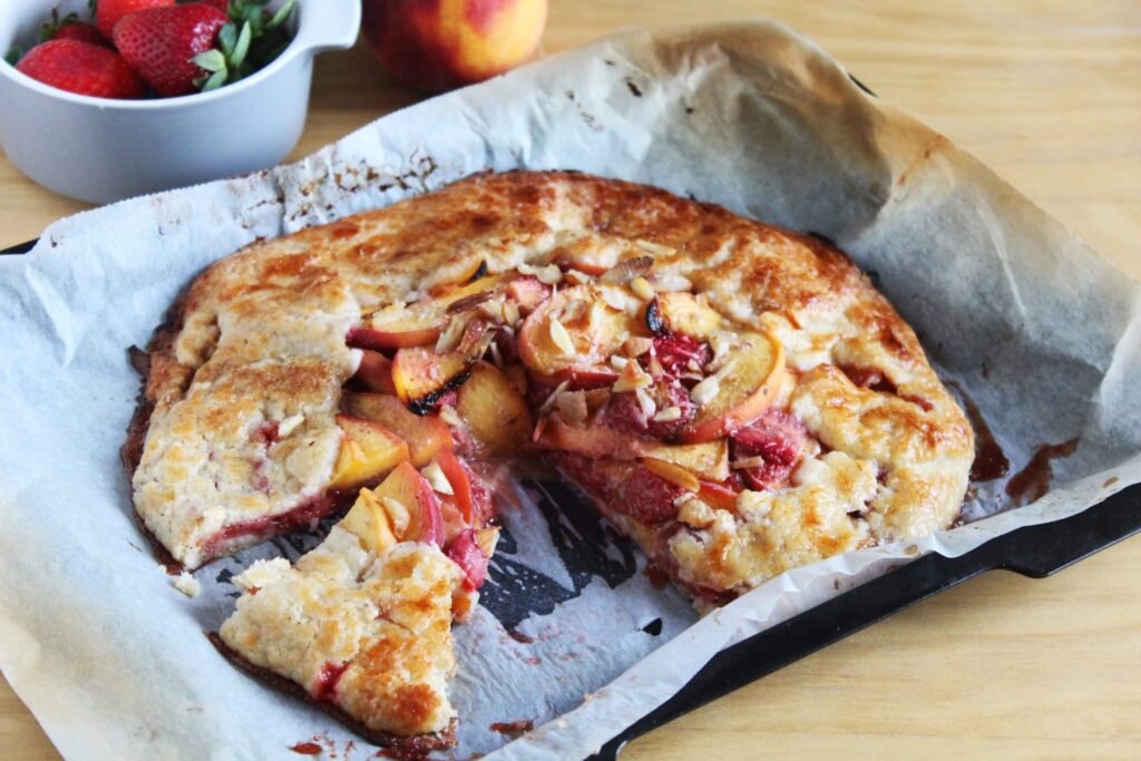 Side perspective showing the thin crispy base layer of the baked fruit galette.