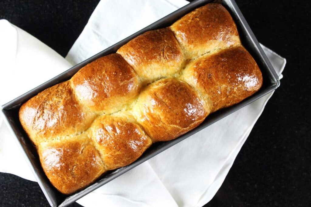 Overhead view showing the golden braided crust of the brioche loaf bread.