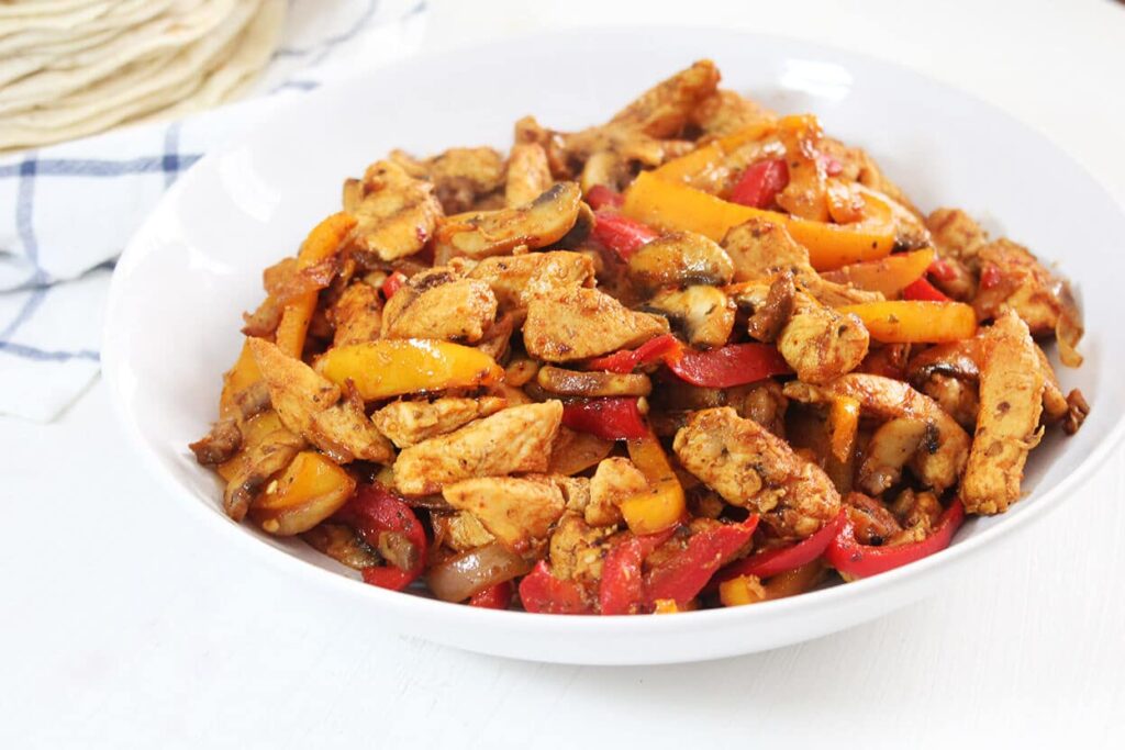 Presentation of the complete sizzling plate of Mexican chicken fajitas.