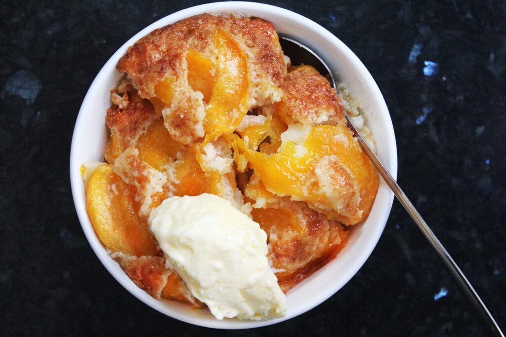 Overhead view showing the rustic crust layer of the peach cobbler.