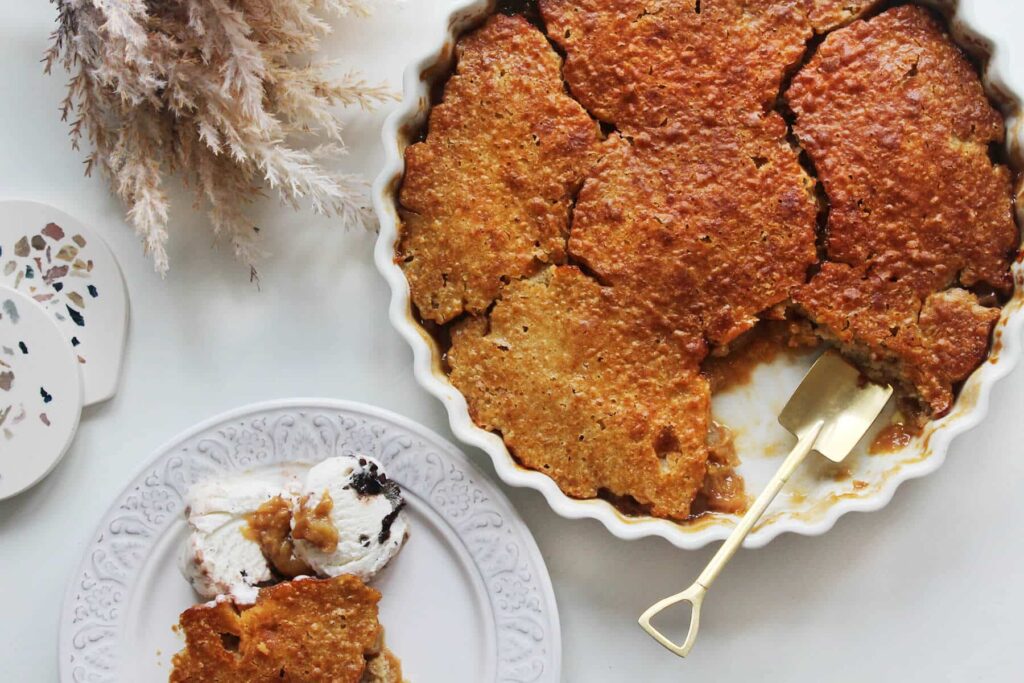 Overhead view showing the rustic top crust of the plum cobbler.