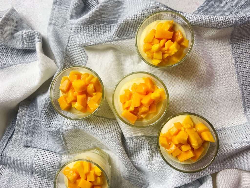 Vista desde arriba (plano cenital) de la porción montada del postre mousse de mango.