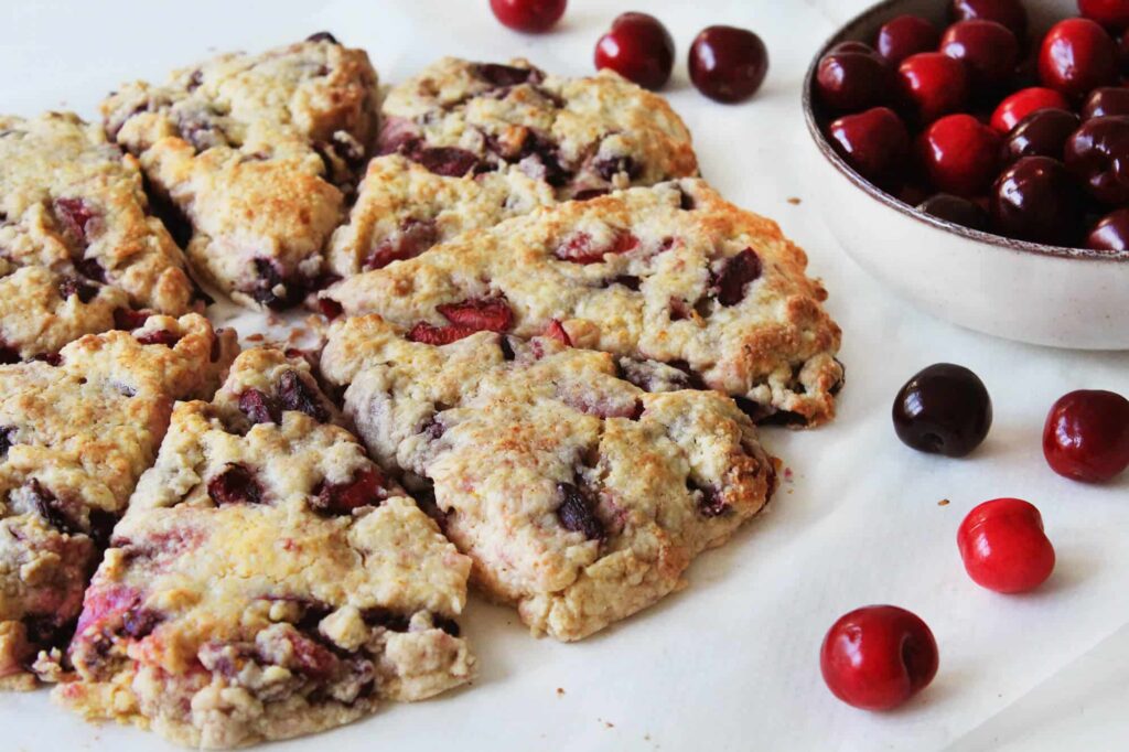 Side perspective showing the high rise and flaky layers of the baked cherry scones.