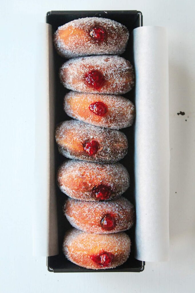 Detailed view focusing on the soft airy interior crumb structure of the marmalade filled doughnuts.