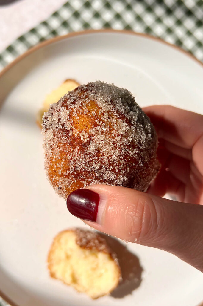 Vista en detalle de la masa de las donas italianas de ricotta espolvoreadas.
