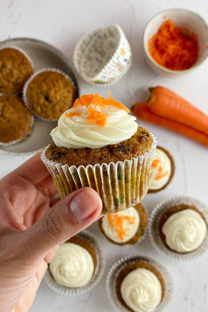 Alternative angle capturing the complete tray presentation of the carrot cupcakes with cream cheese frosting.