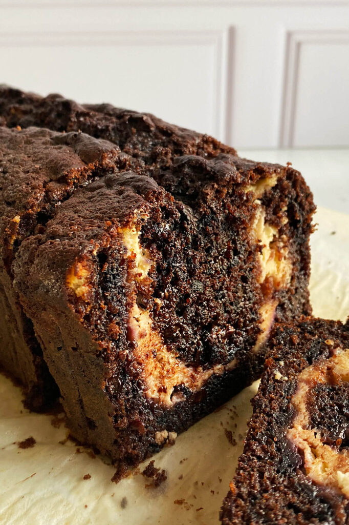 Vista en detalle de la miga suave y las capas integradas de pan de zanahoria morada con chocolate y cheesecake.